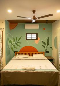 a bedroom with a bed with a flowery wall at Marari Edens in Mararikulam