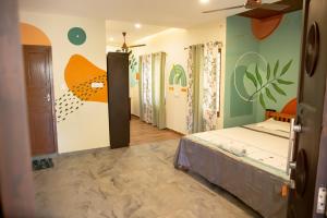 a bedroom with a bed and a mural on the wall at Marari Edens in Mararikulam