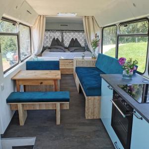 uma caravana com uma cama, uma mesa e cadeiras em Lutzmannhof em Irdning