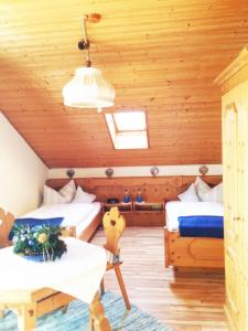 Zimmer mit 2 Betten und einem Tisch in einer Hütte in der Unterkunft Ferienwohnung Gruß aus Partenkirchen in Garmisch-Partenkirchen