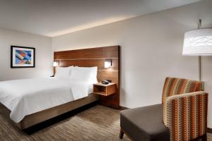 a hotel room with a bed and a chair at Holiday Inn Express Billings East by IHG in Billings +48 photos