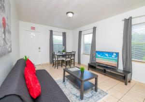 a living room with a couch and a flat screen tv at Hollywood private apartments in Hollywood
