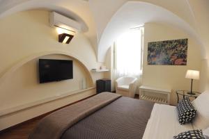 1 dormitorio con 1 cama y TV en la pared en Negramaro Suite B&B, en Lecce