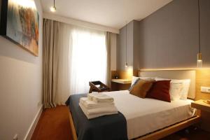 a hotel room with a bed and a window at Timeless Ambassador -Belém in Lisbon