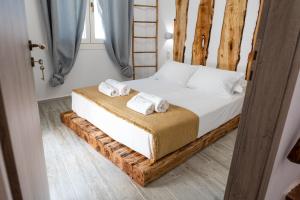 a bedroom with a bed with two towels on it at ONAR LUXURIES in Ermoupoli