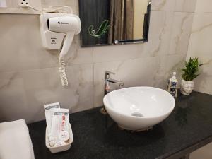 a bathroom with a sink and a phone on a counter at Hotel Mari Aai Residency in Navi Mumbai