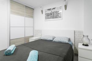 um quarto com uma cama com duas almofadas azuis em Apartamento El Mar 2 em Alicante