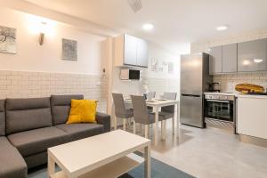 uma sala de estar com um sofá, uma mesa e uma cozinha em Apartamento El Mar 2 em Alicante