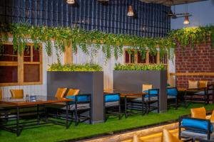 a restaurant with tables and chairs and plants at Hotel Mari Aai Residency in Navi Mumbai