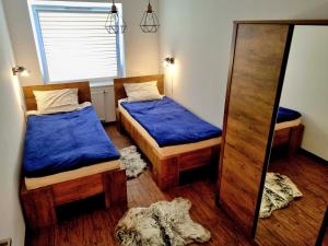 mały pokój z 2 łóżkami i lustrem w obiekcie Apartament 'U PODNÓŻA GROMADZYNIA' w mieście Ustrzyki Dolne