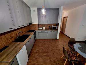 a kitchen with white cabinets and a table and chairs at Apartament 'U PODNÓŻA GROMADZYNIA' in Ustrzyki Dolne