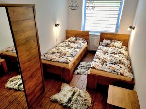 sypialnia z 2 łóżkami i lustrem w obiekcie Apartament 'U PODNÓŻA GROMADZYNIA' w mieście Ustrzyki Dolne