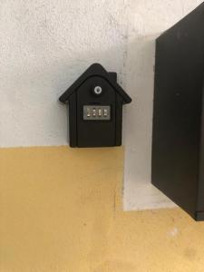 einem schwarzen Wecker an der Ecke einer Wand in der Unterkunft Supercentral one room flat, 16 min to Bergamo airport in Alzano Lombardo
