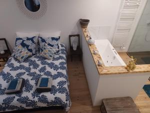 Schlafzimmer mit einem Bett und einer Badewanne in der Unterkunft Chambre d'Emma 