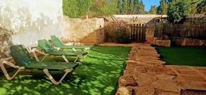 two chairs sitting on the grass in a yard at ca sa tia in Santanyi