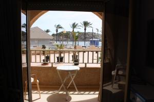 Habitación con vistas a un balcón con mesa y sillas. en Hotel Playa Grande en Puerto de Mazarrón