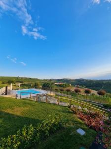 Blick auf einen Garten mit Swimmingpool in der Unterkunft Sedendo e Mirando B&B in Neive
