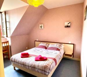 um quarto com uma cama com toalhas vermelhas em Auberge Le Beaulieu -Cantal em Beaulieu