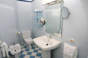 a bathroom with a sink and a toilet and a mirror at Hotel Playa Grande in Puerto de Mazarrón