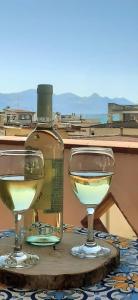 eine Flasche Wein und zwei Gläser auf dem Tisch in der Unterkunft Limoncello Home con Veranda vista Mare a 3 Min dalla spiaggia in Alcamo