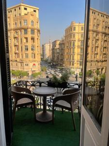 a balcony with tables and chairs and a view of a city at Cairo Inn in Cairo