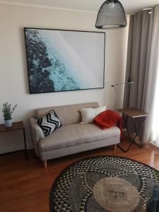 un soggiorno con divano e una foto appesa al muro di Tranquilo y Acogedor departamento en Con Con a Concón