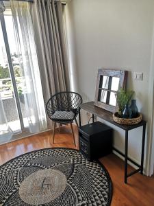 a living room with a table and a chair and a mirror at Tranquilo y Acogedor departamento en Con Con in Concón