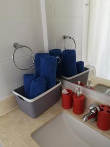 a bathroom with blue towels in trays next to a sink at Tranquilo y Acogedor departamento en Con Con in Concón