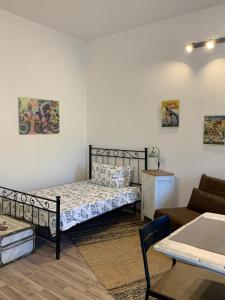 ein Schlafzimmer mit einem Bett, einem Sofa und einem Tisch in der Unterkunft Cà del Prete country room in Valenza