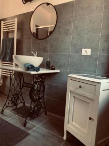 ein Bad mit einem Waschbecken und einem Spiegel in der Unterkunft Cà del Prete country room in Valenza