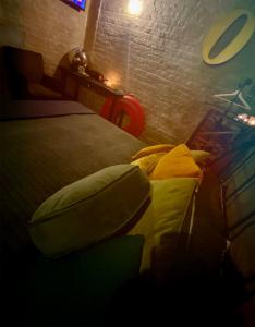 - une chambre avec un lit et un mur en briques dans l'établissement Les chambres atypiques de Nico Bush - Parking sécurisé vélos, à Tournai