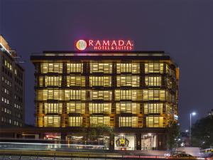 a building with a sign on top of it at night at Ramada Hotel & Suites by Wyndham Istanbul- Sisli in Istanbul