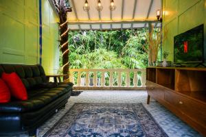 sala de estar con sofá y balcón en Villa Kamar Tamu Selomartani 2 en Sleman