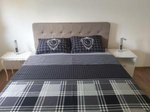 Un dormitorio con una cama con sábanas y almohadas azules y blancas en Mia Casa, en Tivat