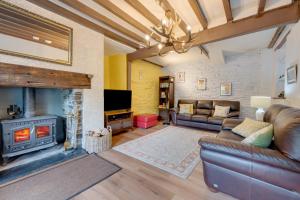 a living room with a couch and a fireplace at Gwel y Bryn in Corris