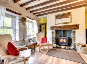 a living room with a fireplace and chairs at Gwel y Bryn in Corris