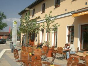 two people sitting in chairs outside of a building at Gasthof Strausberg Nord in Strausberg