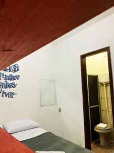una camera con letto, specchio e servizi igienici di Ammonite Hostel - Itacaré a Itacaré Altre 41 foto