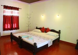 a bed in a room with a red window at Marari diya homestay in Mararikulam