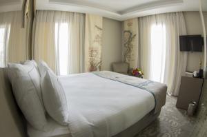 a bedroom with a large bed with white sheets and pillows at Peyk Hotel in Istanbul
