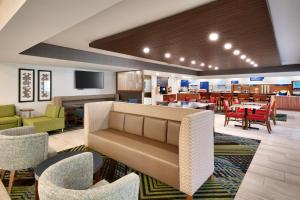 a lobby with a couch and tables and chairs at Holiday Inn Express & Suites Mitchell, an IHG Hotel in Mitchell