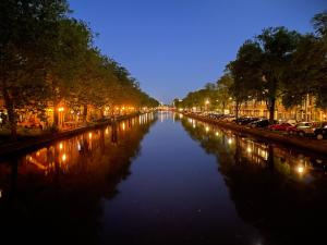 a view of a river at night with cars parked at Bed and Breakfast Amsterdam in Amsterdam