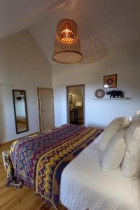 1 dormitorio con cama y lámpara de araña en La Maison de Fleurat en Domeyrot