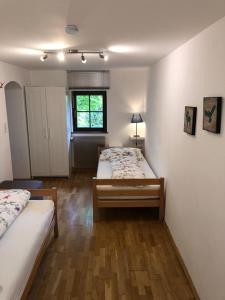 een slaapkamer met 2 bedden en een raam bij Ferienwohnung Woferlbauer in Au