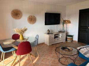 a living room with a table and a tv at Villa carioca appartement bâbord in Gujan-Mestras