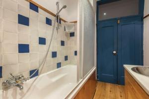 a bathroom with a tub and a sink and a blue door at Magnificent Historical City Centre Apart with Terrace in Lisbon