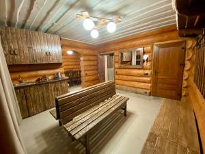 a wooden bench in a room with a kitchen at Complex MAYARIV in Makariv