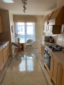 a kitchen with a stove and a table with chairs at Hopetoun Apartment with free parking in Edinburgh