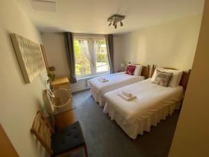 a hotel room with two beds and a window at Hopetoun Apartment with free parking in Edinburgh