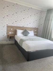 a bedroom with a bed with birds on the wall at The Clarendon Hotel in Morecambe